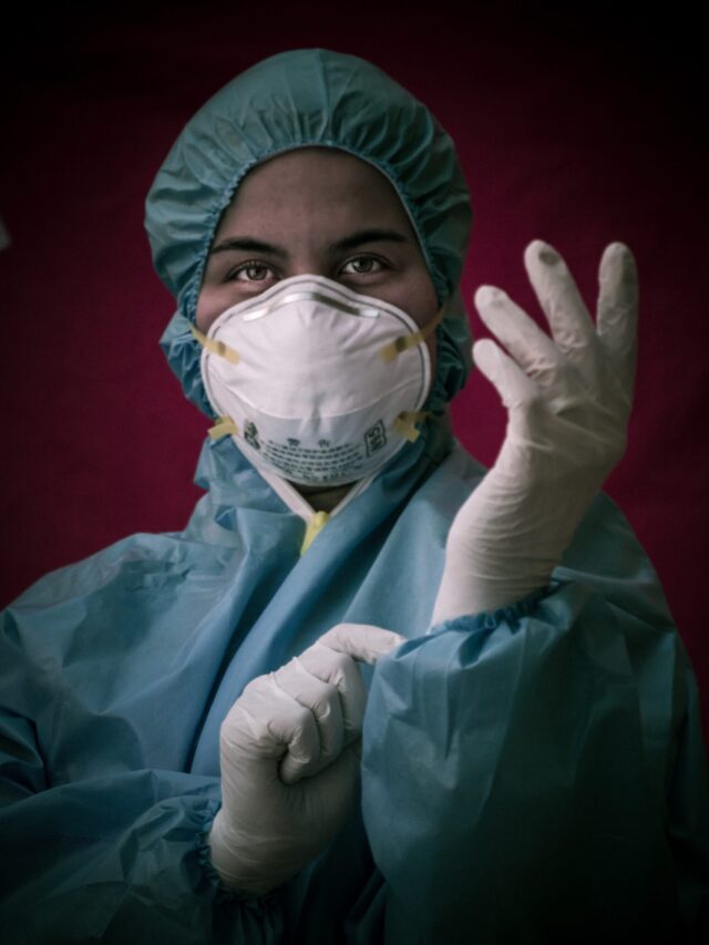 A lab personnel with mask, head cap and gloves.